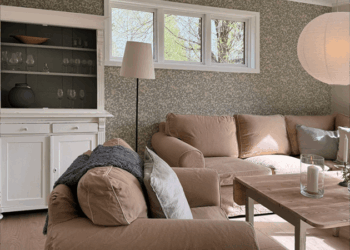 Detailblick in das Wohnzimmer, im Vordergrund ein Sessel, im Hintergrund eine Couch