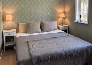 Schlafzimmer mit Nachtschränken und Fenster, sehr gemütlich