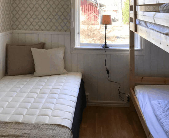 Blick aus dem Fenster im Kinderschlafzimmer mit Doppelstockbett und Bett